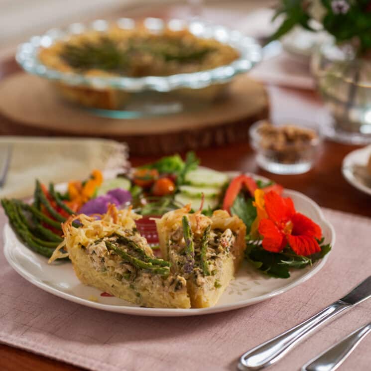 A hash brown bottom quiche served with asparagus and salad